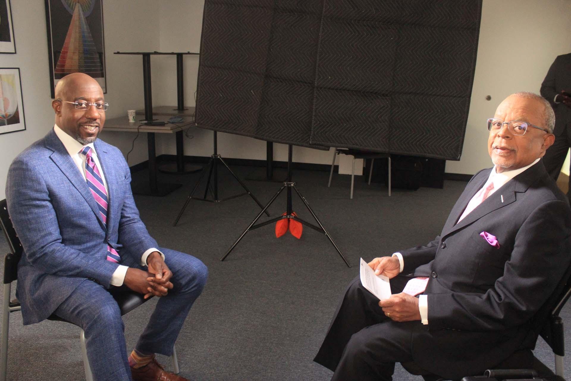 Host, Henry Louis Gates Jr. poses for a photo with U.S. Senator, Raphael Warnock