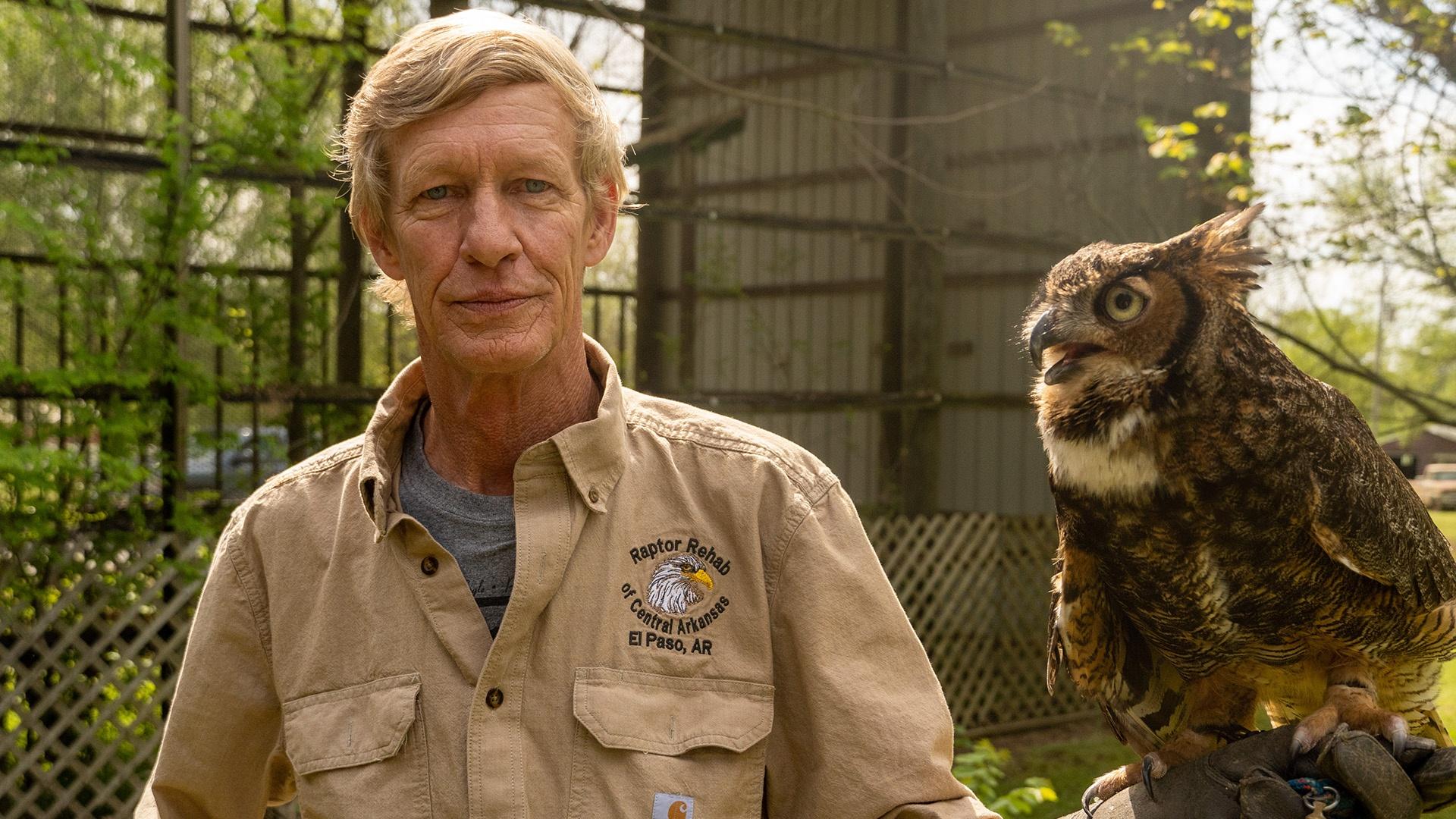 Rodney holding a bird and looking at camera